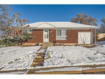 Brick ranch house with attached garage, snow-covered yard, and walkway at 10516 Humboldt St, Northglenn, CO 80233