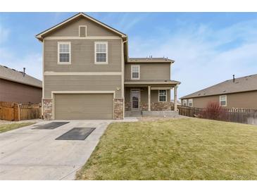 Two-story house with attached garage and landscaped lawn at 260 Iron St, Lochbuie, CO 80603