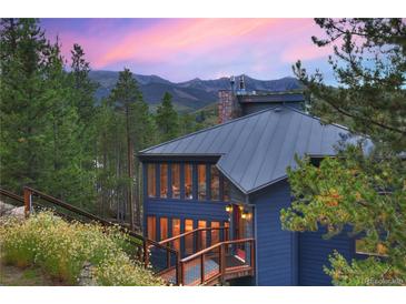 Mountain home exterior at dusk, showcasing a large deck and mountain views at 141 Shekel Ln, Breckenridge, CO 80424