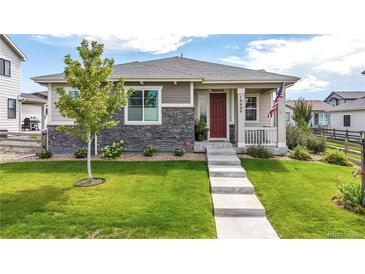Modern two-story home with stone accents and a red door at 18000 E 100Th Ave, Commerce City, CO 80022