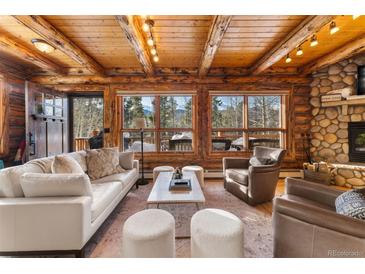 Cozy living room with stone fireplace and mountain views at 878 American Way, Breckenridge, CO 80424