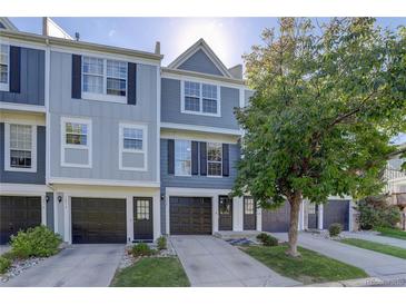 Gray townhome exterior with double-car garage and landscaping at 12008 E Tennessee Dr, Aurora, CO 80012