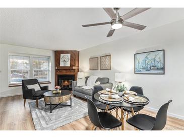 Bright living room with fireplace, dining area, and hardwood floors at 1100 S Waco St # G, Aurora, CO 80017