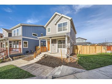 Two-story gray house with orange door, wooden fence, and small front yard at 10291 E 62Nd Pl, Denver, CO 80238