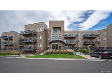 Exterior of an apartment building with multiple balconies and landscaping at 6000 W Floyd Ave # 107, Denver, CO 80227