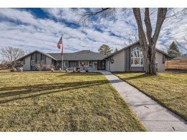 Gray ranch house with landscaped lawn and walkway at 7000 S Sheridan Blvd, Littleton, CO 80128