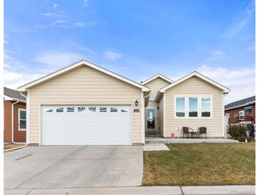 Beige house with a two-car garage and landscaping at 6280 Indian Paintbrush St, Frederick, CO 80530
