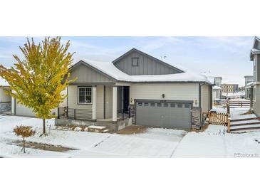 Craftsman style home with snow covered yard at 18129 E 99Th Pl, Commerce City, CO 80022