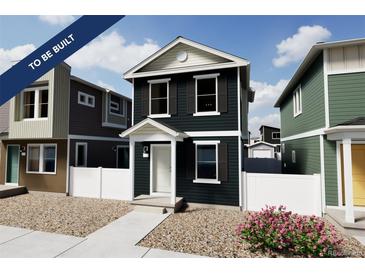 Two-story home with dark-green exterior, white trim, and landscaping at , Commerce City, CO 80022