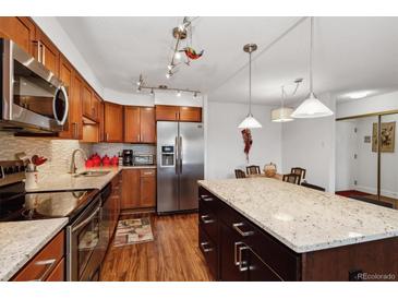 Modern kitchen with stainless steel appliances and island at 725 S Alton Way # 3B, Denver, CO 80247