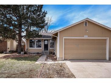 Tan house with attached garage and landscaping at 16812 E Mansfield Cir, Aurora, CO 80013