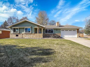 Ranch style home with green siding, brick accents, and a two-car garage at 17 Dartmouth Cir, Longmont, CO 80503