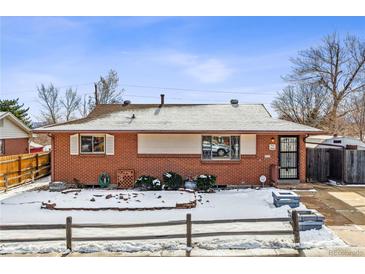 Brick ranch home with a landscaped yard and snowy front lawn at 3520 W Dill Rd, Englewood, CO 80110