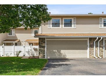 Tan two-story townhome with attached garage and small front yard at 3228 S Xanadu St, Aurora, CO 80014