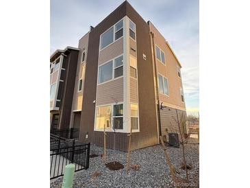 Modern three-story townhome with stone and neutral siding at 14245 Currant St, Broomfield, CO 80020