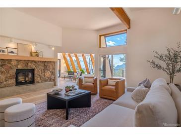 Spacious living room with stone fireplace and large windows at 225 Bristlecone Way, Boulder, CO 80304