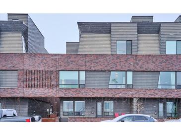 Modern brick townhome exterior with large windows and covered porch at 3933 Inca St, Denver, CO 80211