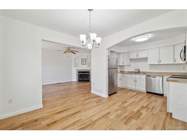 Bright kitchen features white cabinets, stainless steel appliances, and light countertops at 1745 W 102Nd Ave, Thornton, CO 80260