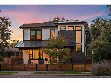 Modern two-story home with a gray and white exterior, wood fence, and landscaping at 4135 Perry St, Denver, CO 80212