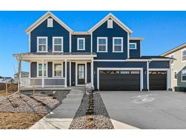 Two-story farmhouse-style home with a charming front porch and a three-car garage at 959 Eldorado Ln, Louisville, CO 80027