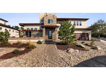 Two-story home with stone and stucco exterior, landscaping, and walkway at 4473 Echo Dr, Larkspur, CO 80118