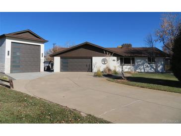 Ranch-style home with attached garage and landscaped yard at 2262 Ammons St, Lakewood, CO 80214