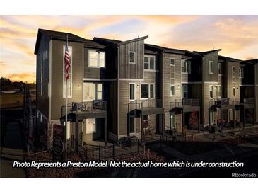 Modern three-story townhome with gray siding and a flag at 2672 W 68Th Ave, Denver, CO 80221