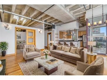 Open living area with hardwood floors, exposed beams, and modern furniture at 1020 15Th St # 202, Denver, CO 80202