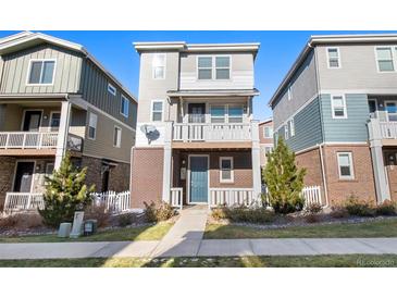 Brick front elevation of a two-story townhome with a small front yard at 12712 E Caspian Pl, Aurora, CO 80014