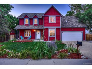 Charming two-story red house with landscaped yard and attached garage at 6885 W 68Th Ave, Arvada, CO 80003