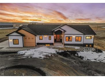 Stunning aerial view of a two-story home with a large yard at sunset at 44035 Pony Express Ct, Elizabeth, CO 80107