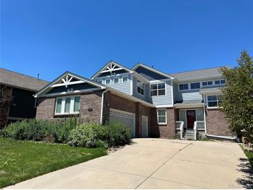 Two-story home with brick and siding exterior, attached garage, and landscaping at 6309 S Newbern Way, Aurora, CO 80016