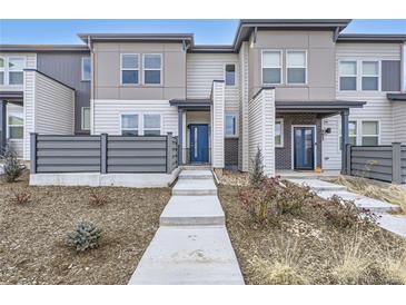 Modern two-story townhome with gray and white siding, and a landscaped front yard at 6621 N Ceylon St, Denver, CO 80249