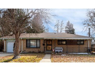 Ranch style home with brick facade, attached garage, and mature landscaping at 3112 Salem St, Aurora, CO 80011