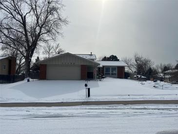 Brick ranch house in snowy front yard at 11132 E Harvard Dr, Aurora, CO 80014