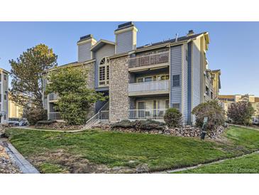 Two-story building with stone and siding exterior, balconies, and landscaping at 8853 Colorado Blvd # A-106, Thornton, CO 80229