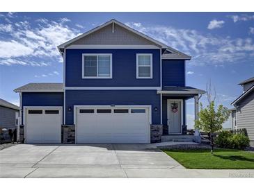 Two-story blue house with white two-car garage and landscaping at 45780 Silverdrop Ave, Bennett, CO 80102