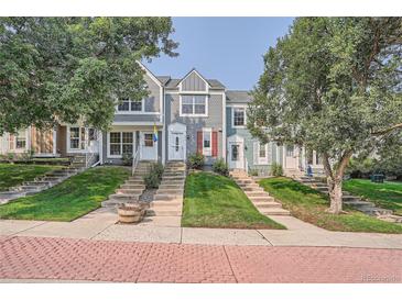 Three-story townhouses with gray siding and landscaping at 10569 W Dartmouth Ave, Lakewood, CO 80227