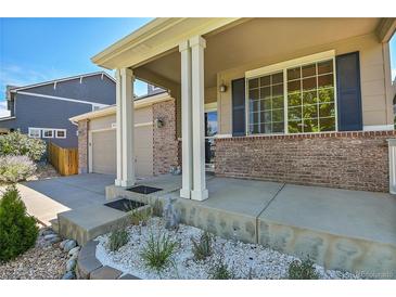 Two-story home with brick facade, covered porch, and landscaped front yard at 4037 S Odessa Cir, Aurora, CO 80013