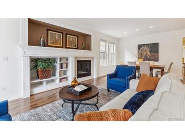 Elegant living room boasting hardwood floors, fireplace, and built-in shelving at 8490 W Quarles Dr, Littleton, CO 80128