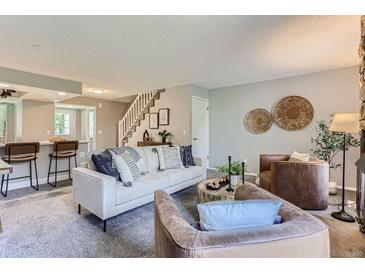 Bright living room with comfy seating, a fireplace, and access to a patio at 1649 S Ivory Cir # D, Aurora, CO 80017