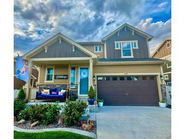 Two-story house with a brown and beige exterior, landscaped front yard, and a two-car garage at 417 Altona Way, Erie, CO 80516