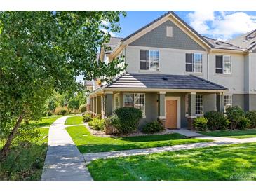 Two-story townhome with a front porch and landscaped yard at 22580 E Ontario Dr # 103, Aurora, CO 80016