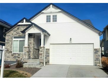 Modern two-story house with a white exterior, stone accents, and a large driveway at 16487 E 111Th Pl, Commerce City, CO 80022