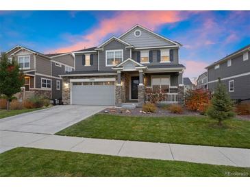 Two-story home with gray siding, attached garage, and landscaped lawn at 23890 E Minnow Dr, Aurora, CO 80016
