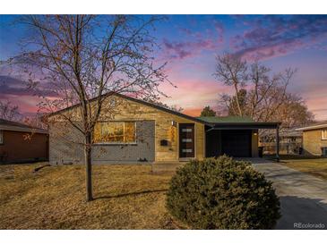 Remodeled Ranch home with modern gray siding, wood accents, and carport at 6035 Everett St, Arvada, CO 80004