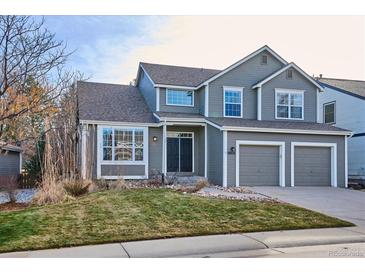 Two-story house with gray siding, a double garage, and landscaping at 10036 Hughes Pl, Highlands Ranch, CO 80126