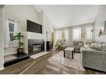 Living room with gas fireplace, hardwood floors, and a sectional sofa at 970 S Dawson Way # 10, Aurora, CO 80012