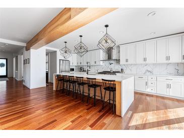 Spacious kitchen featuring white cabinets, a large island, and hardwood floors at 1357 S Saint Paul St, Denver, CO 80210