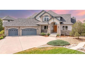 Stunning two-story home with stone facade and gray garage doors at 1199 Links Ct, Erie, CO 80516